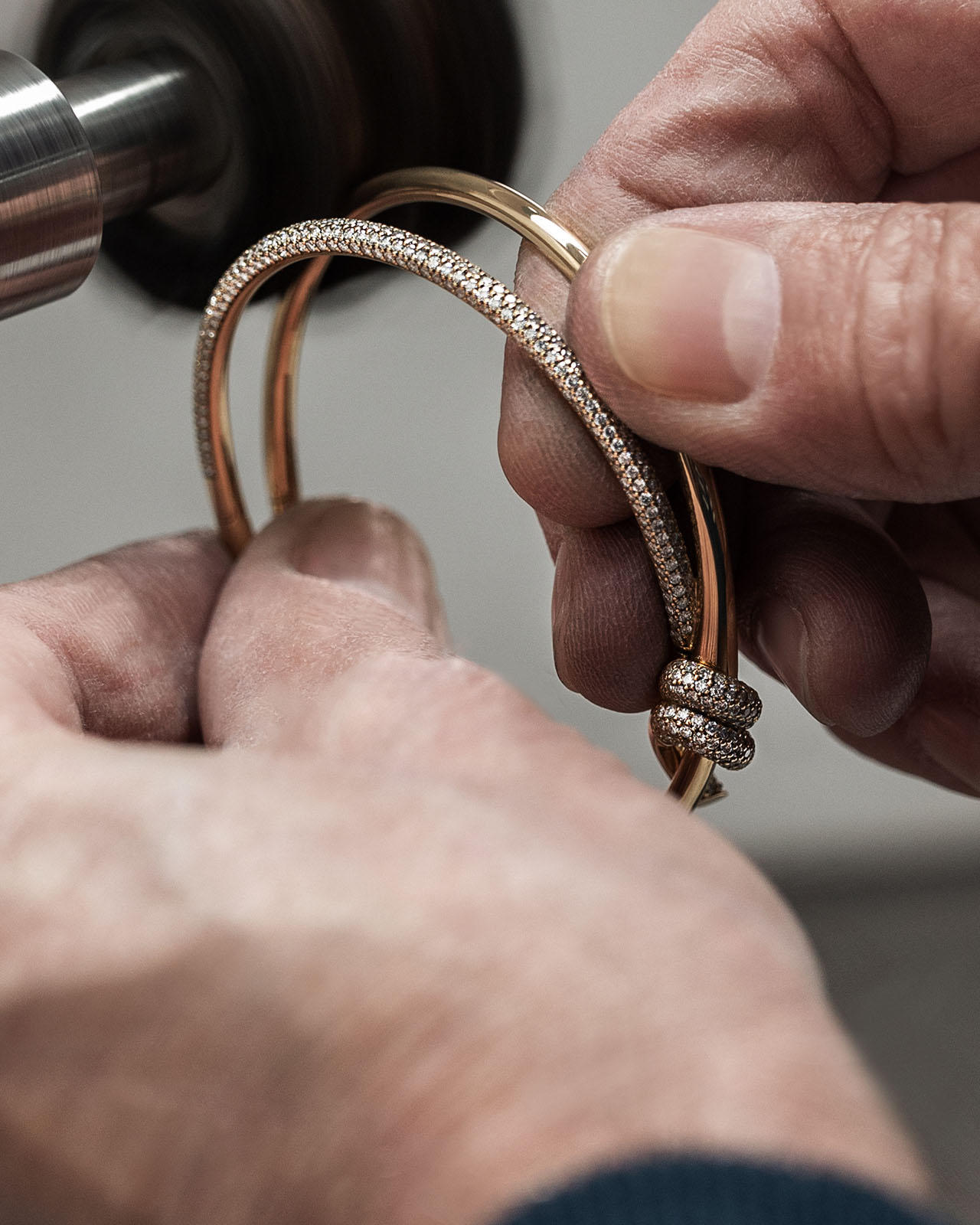 Two hands delicately holding a bracelet, emphasizing a product care and repair service.